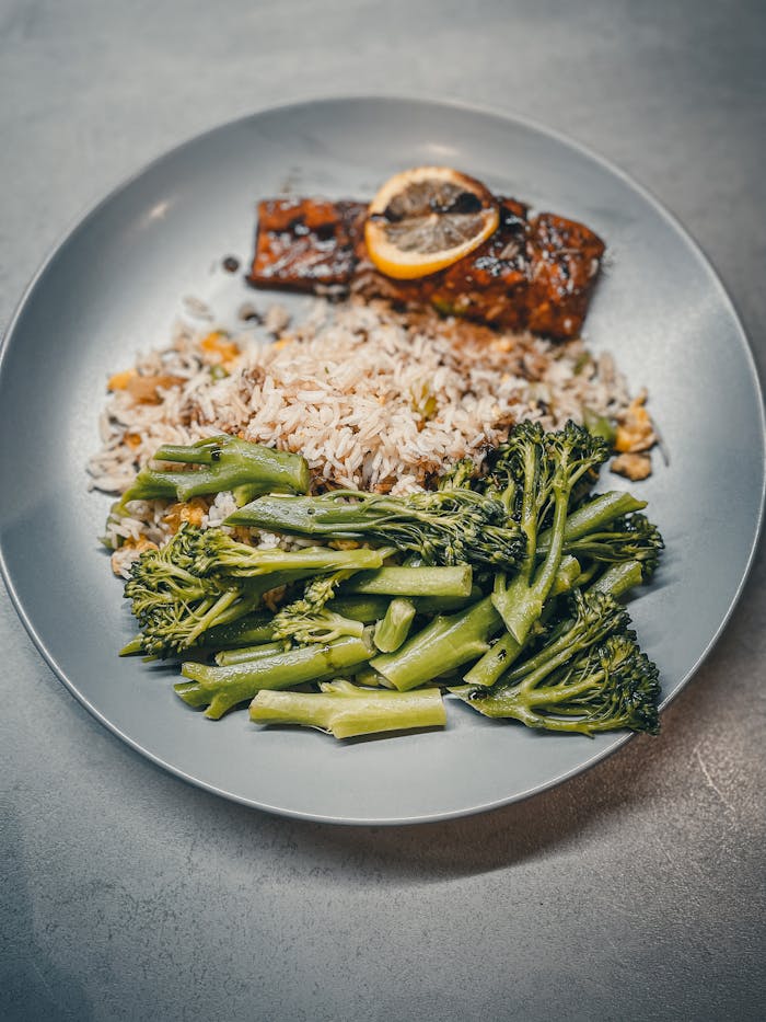 Delicious meal featuring grilled salmon, seasoned rice, and steamed broccoli.